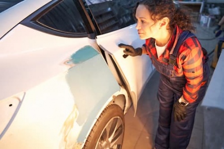 concentrated-female-mechanic-looking-at-car-body-2025-03-08-03-10-40-utc (1).jpg